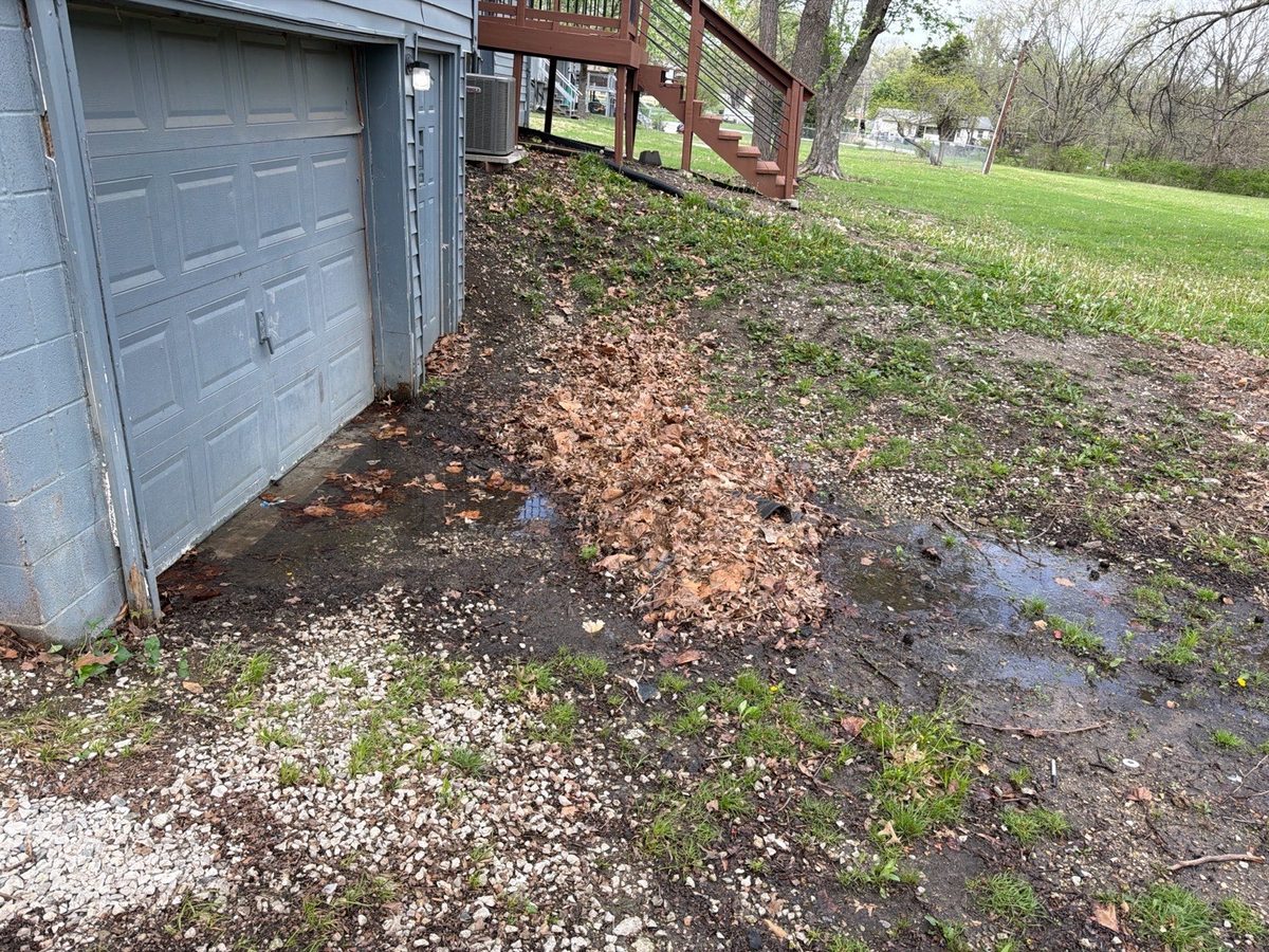 Negative grading and pooled water on the soil at a garage wall found during a home inspection in Belton, MO