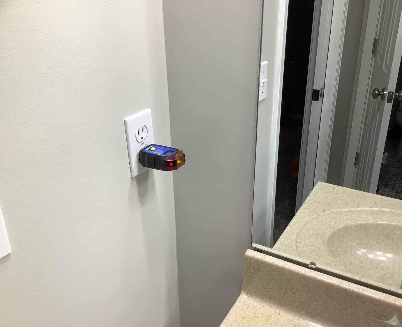 Reversed polarity on a bathroom outlet, shown by an outlet tester, found during a home inspection in Grain Valley, MO