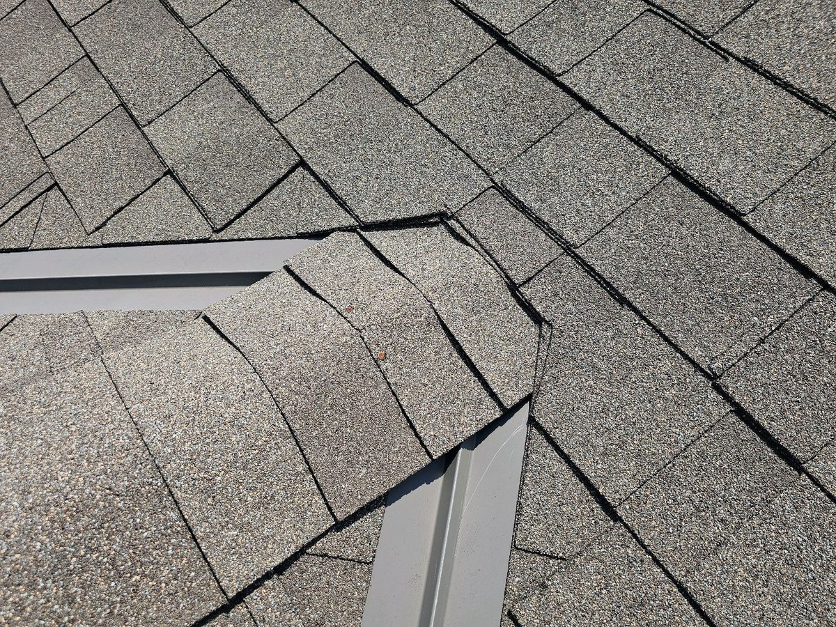 Exposed nail heads on asphalt shingles near a roof valley found during a home inspection in Grain Valley, MO