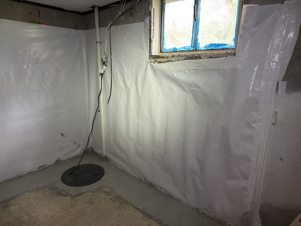 Basement with an interior drainage system, wall liner and sump basin installed to manage water found during a home inspection in Kansas City, MO