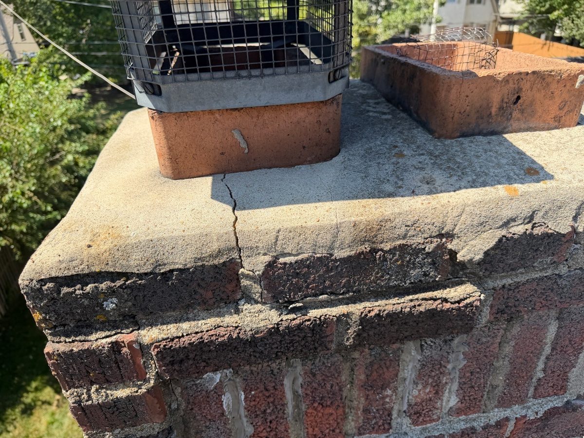 Crack running through a chimney crown and into the brick below, found during a home inspection in Kansas City, MO