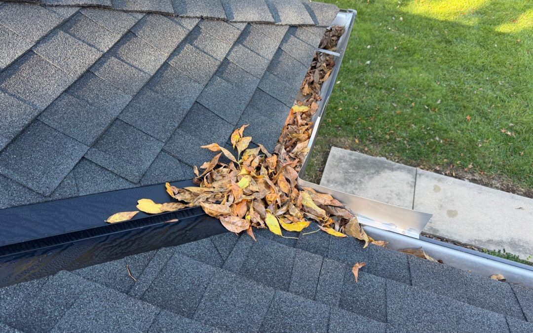 Fallen leaves piled in a gutter where two roof slopes meet, found during a home inspection in Kansas City, MO