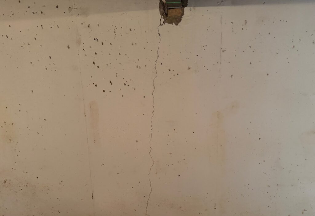 Vertical crack running down a concrete basement wall, found during a home inspection in Leawood, KS