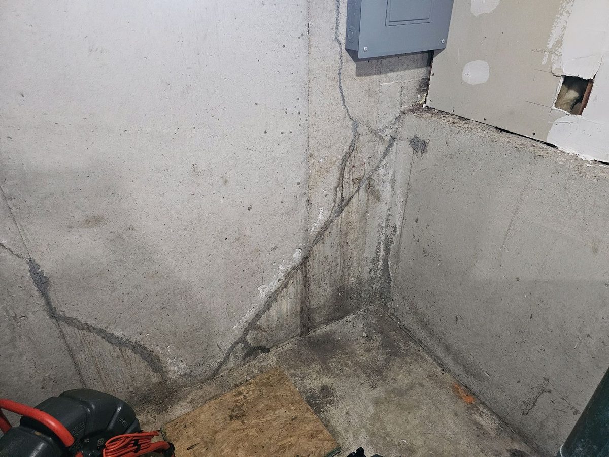 Cracked basement wall corner with water staining from past water entry found during a home inspection in Lenexa, KS