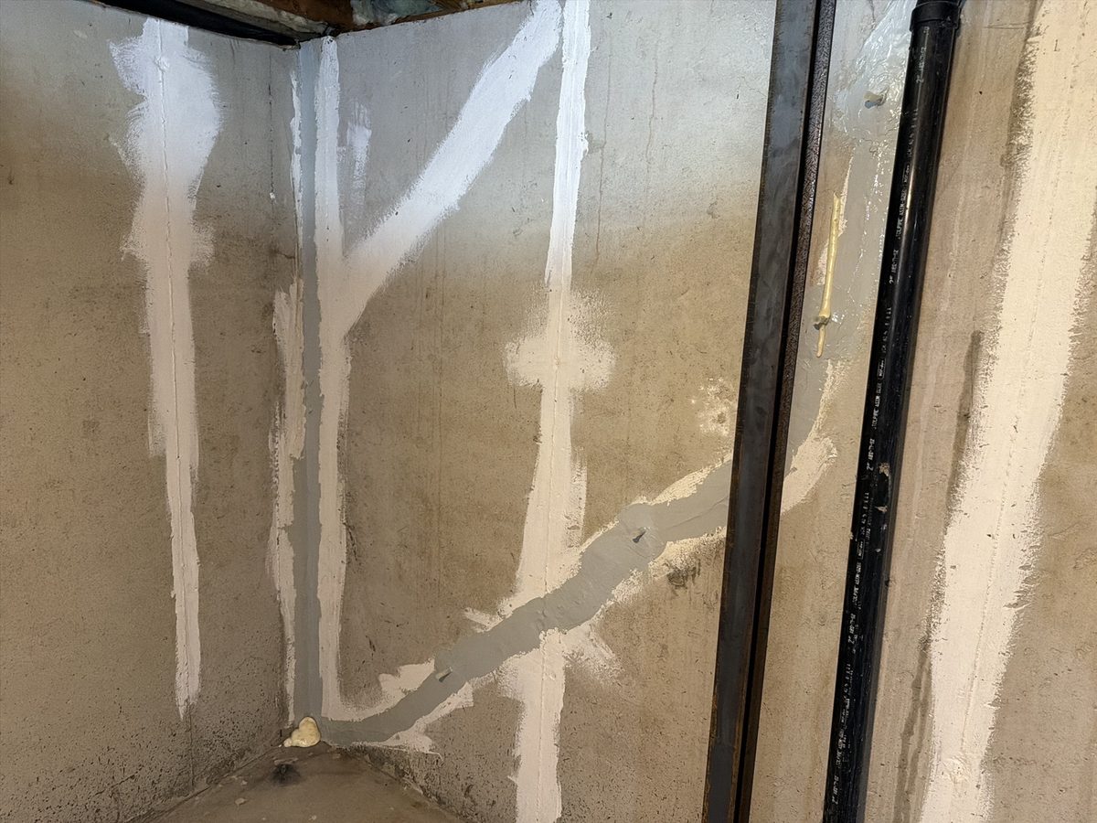 Sealed foundation wall cracks at a basement corner, with a steel wall brace, found during a home inspection in Overland Park, KS
