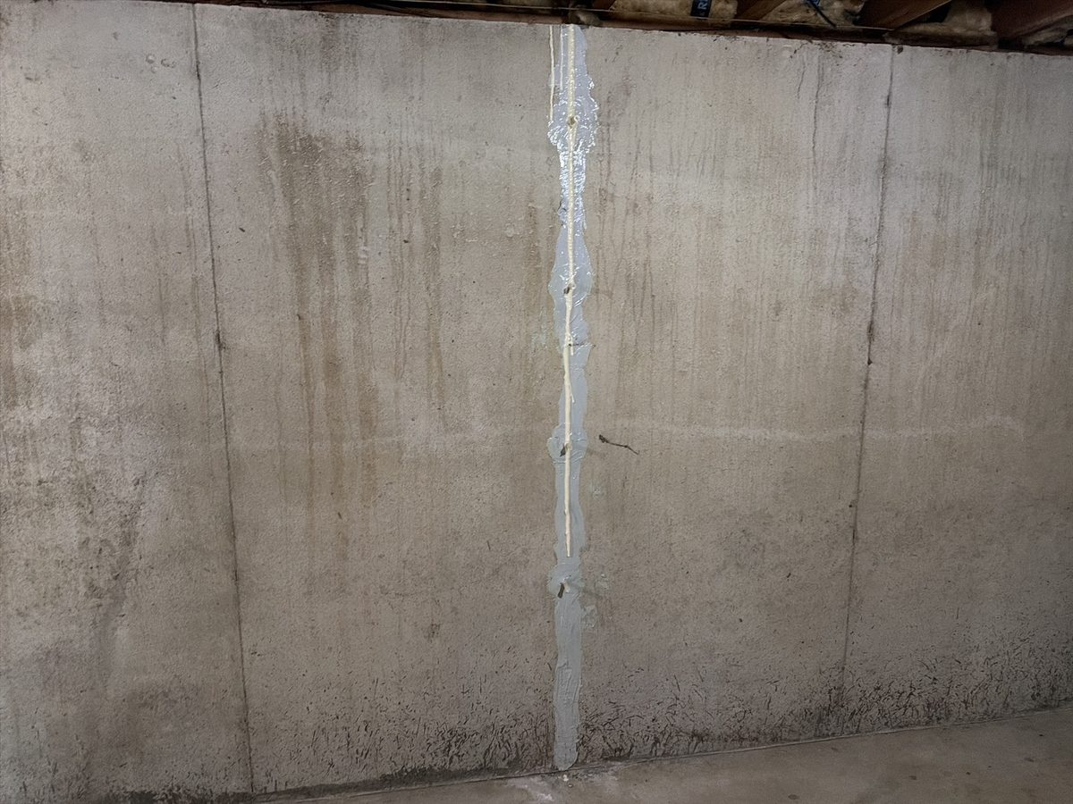 Vertical crack in a poured concrete basement wall that was injected and sealed, found during a home inspection in Overland Park, KS
