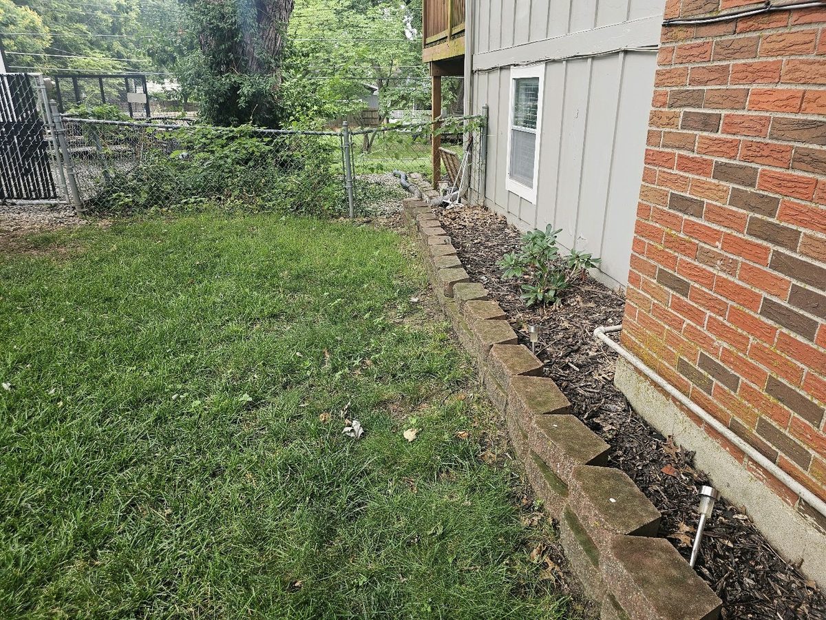 Flat grading on the soil beside a brick and siding foundation wall found during a home inspection in Overland Park, KS