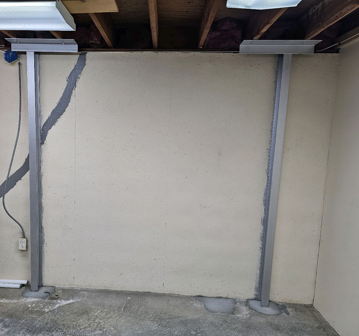 Two steel wall braces and a sealed diagonal crack on a basement foundation wall found during a home inspection in Overland Park, KS
