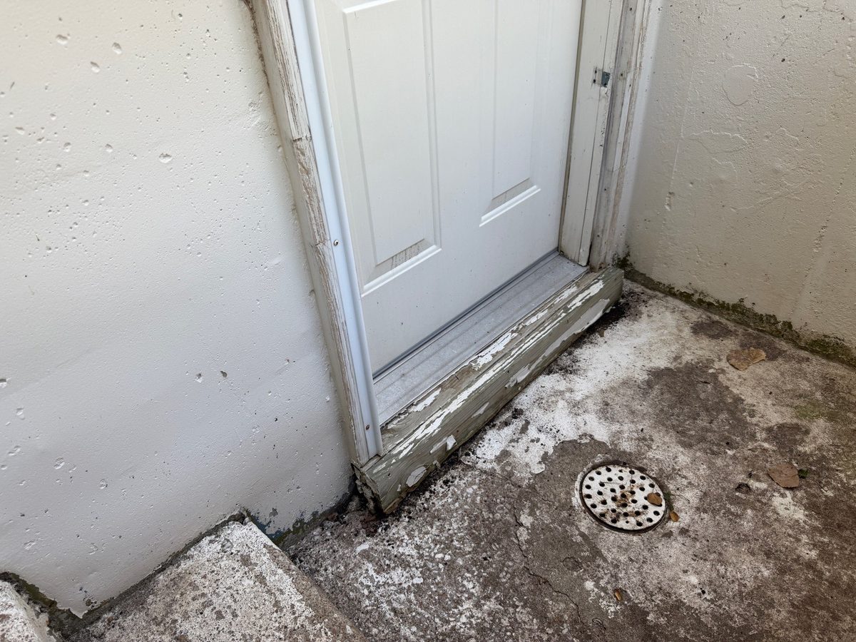 Wood rot on the trim and threshold of a basement stairwell door found during a home inspection in Overland Park, KS