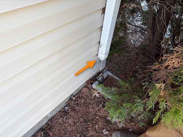 Downspout draining at the foundation found during a home inspection in Raymore, MO