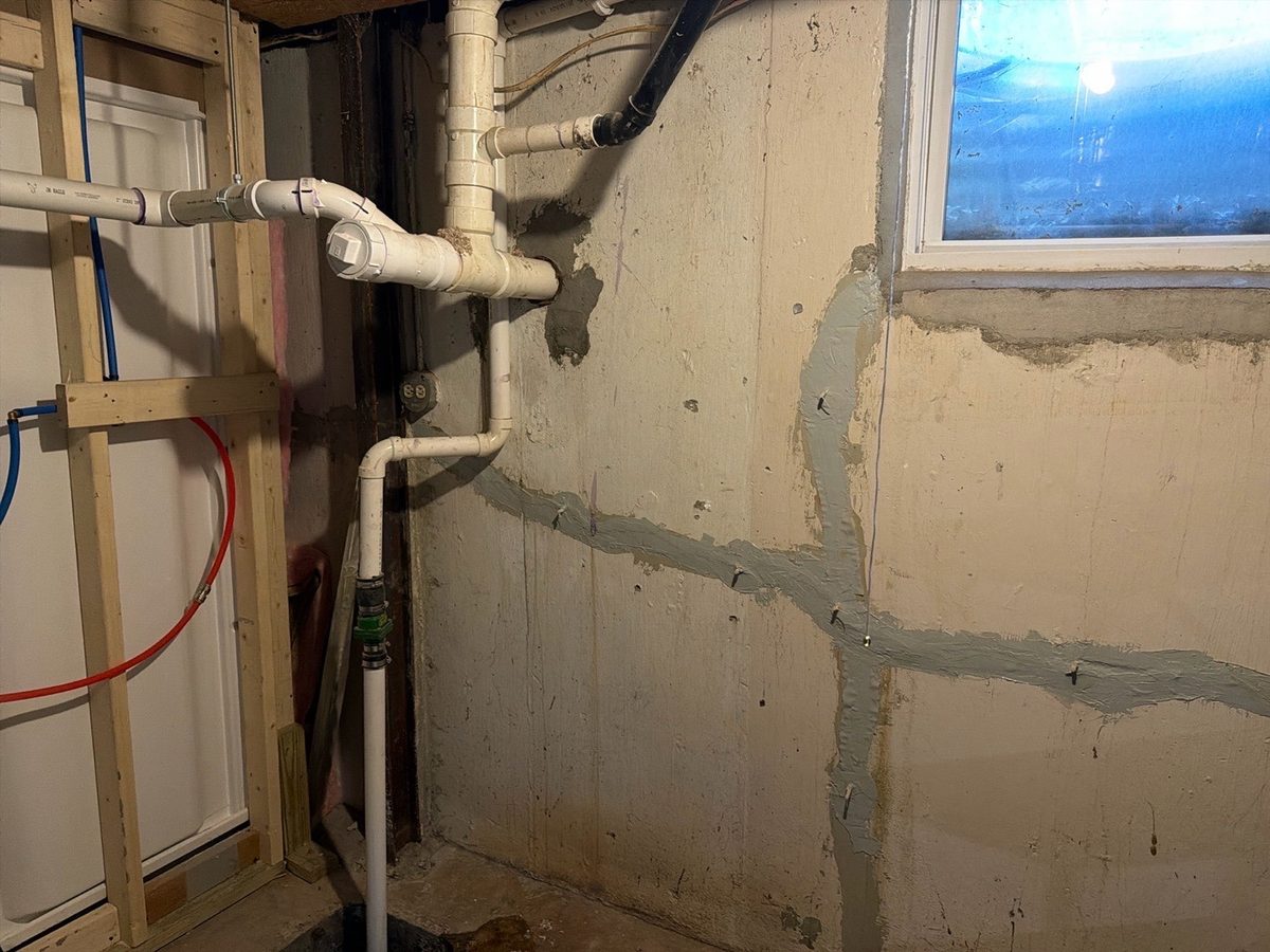 Earlier crack repairs with injection ports still in place on a poured basement wall found during a home inspection in Raytown, MO