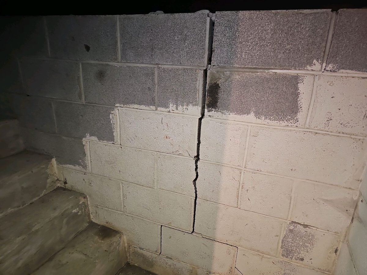 Wide vertical and stepped crack in a concrete block basement wall found during a home inspection in Raytown, MO