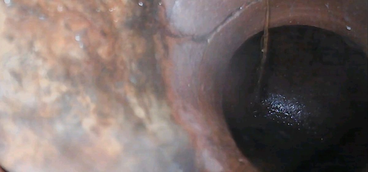 Hairline crack in a clay sewer fitting near the city main found during a sewer scope in Lee's Summit, MO