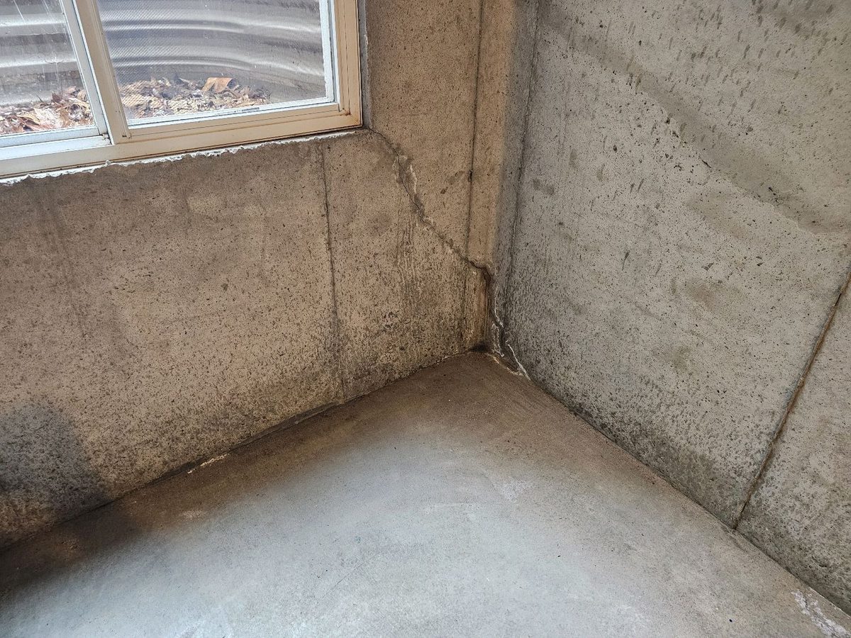 Basement wall crack with efflorescence and moisture staining below a window found during a home inspection in Shawnee, KS