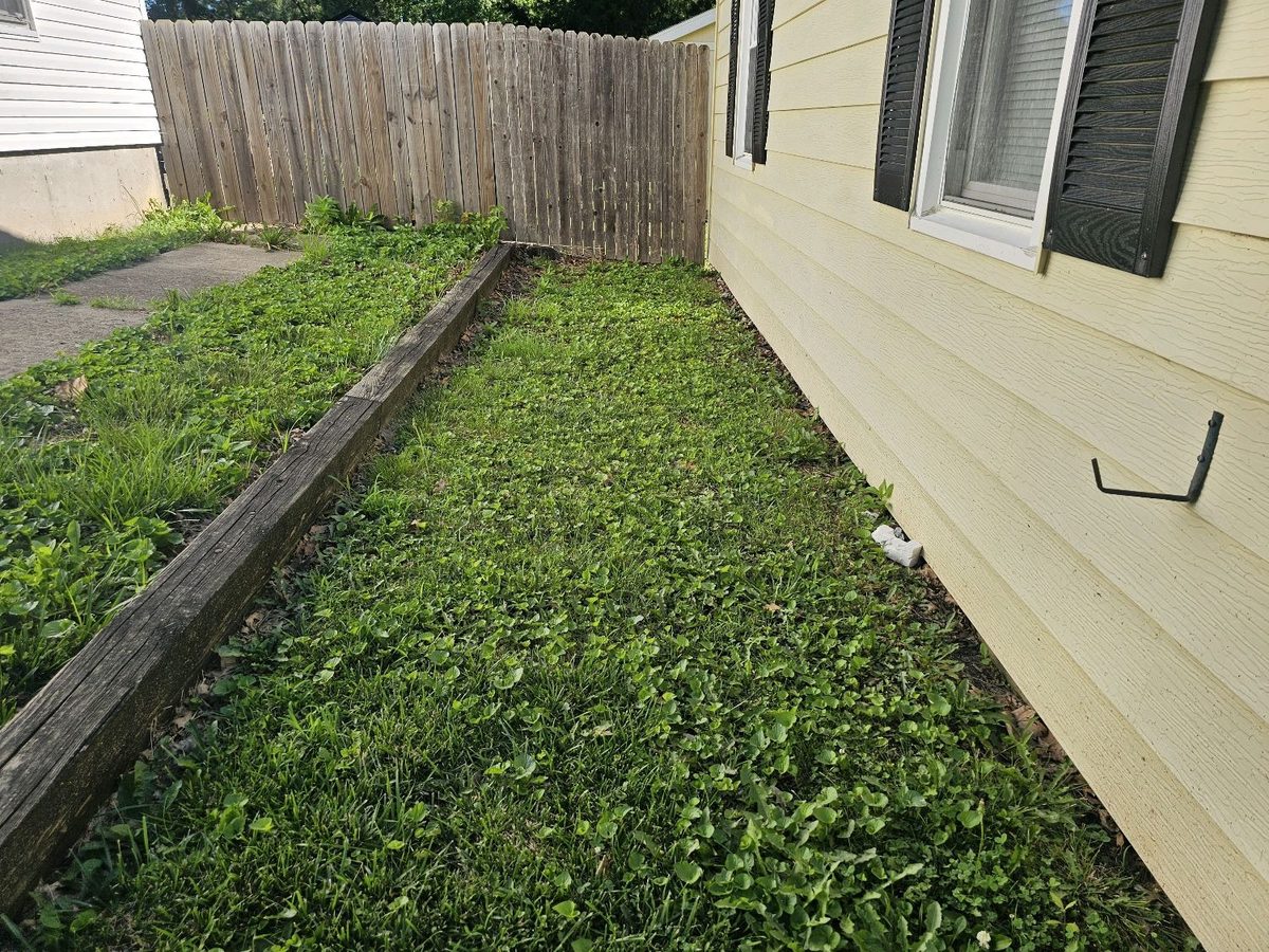 Negative grading with soil sloping toward the siding on a side yard found during a home inspection in Shawnee, KS